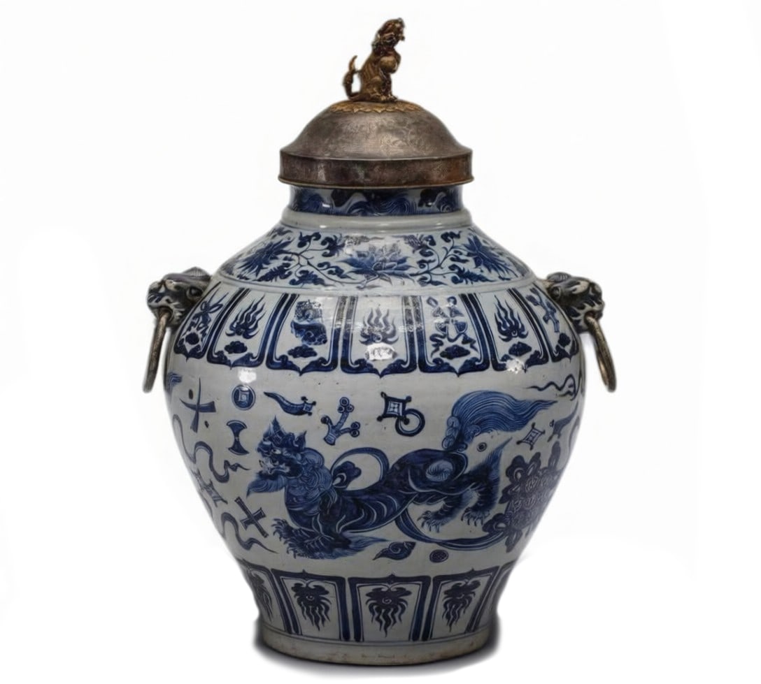 Yuan Dynasty Blue and White Jar with Lion Motifs and Animal Mask Handles: H:35cm This is a Yuan Dynasty blue and white jar with lion motifs and animal mask handles, fitted with a later gilt-lion knob lid—an important Yuan blue and white piece. Fired from fine porcelain cl