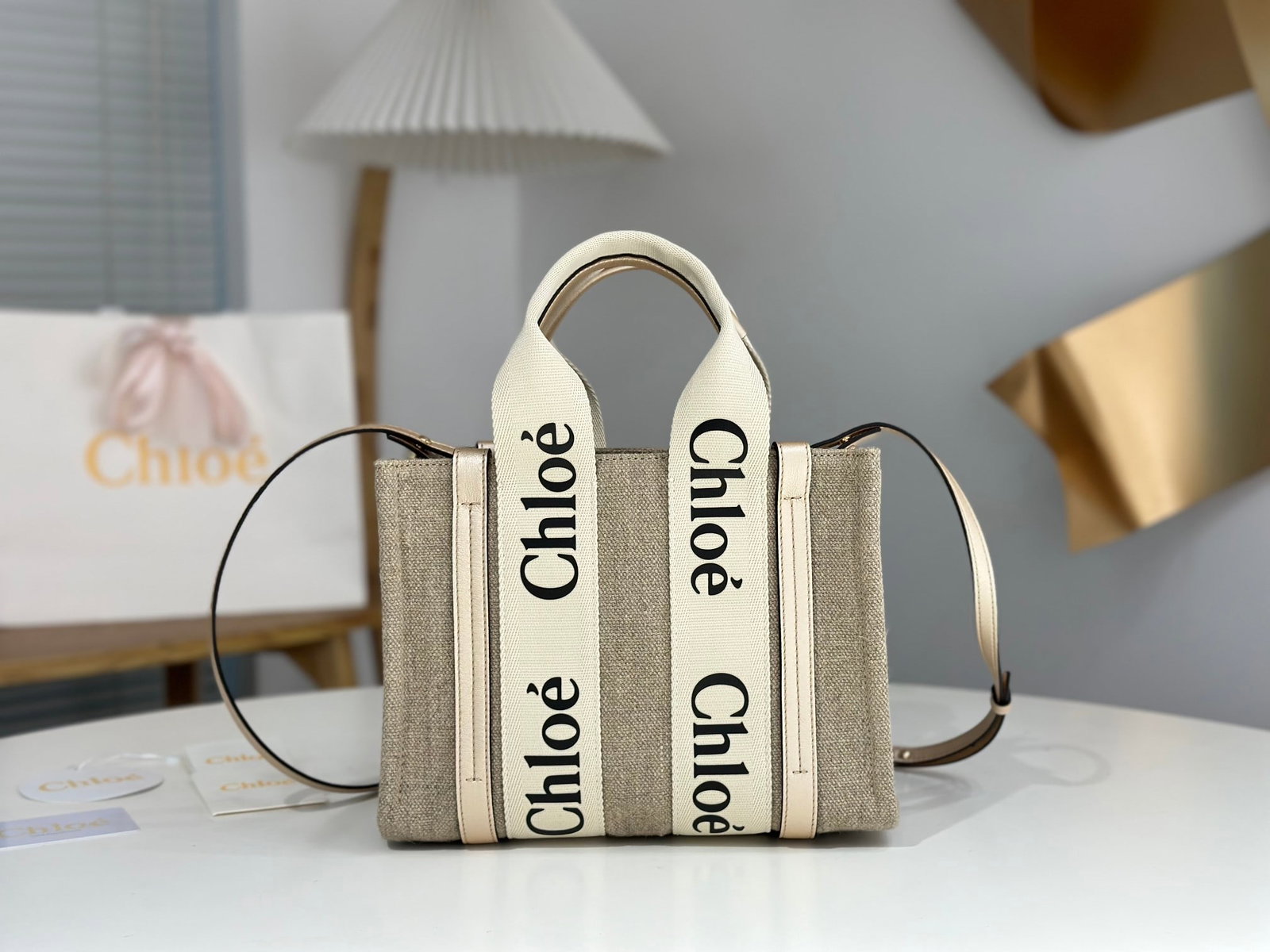 Chloe Woody: This Chloe Woody handbag in gold foil features clean, modern lines and contrasting vertical leather stripes. The unique Chloe ribbon bag is crafted from linen and metallic calfskin, creating an elegan