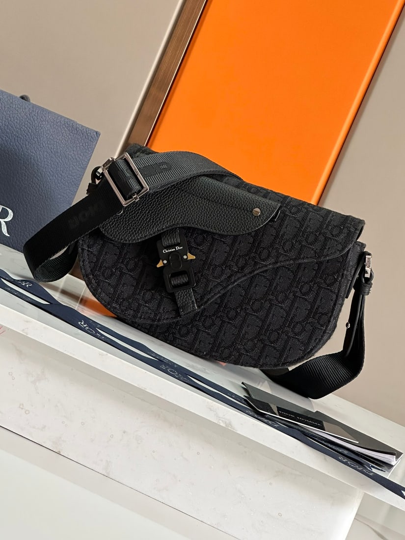 Christian Dior Oblique: The Saddle Messenger Bag is a sophisticated and stylish piece from the Fall 2024 menswear collection. Crafted from beige and black Oblique printed fabric, it features a black grained calfskin saddle f