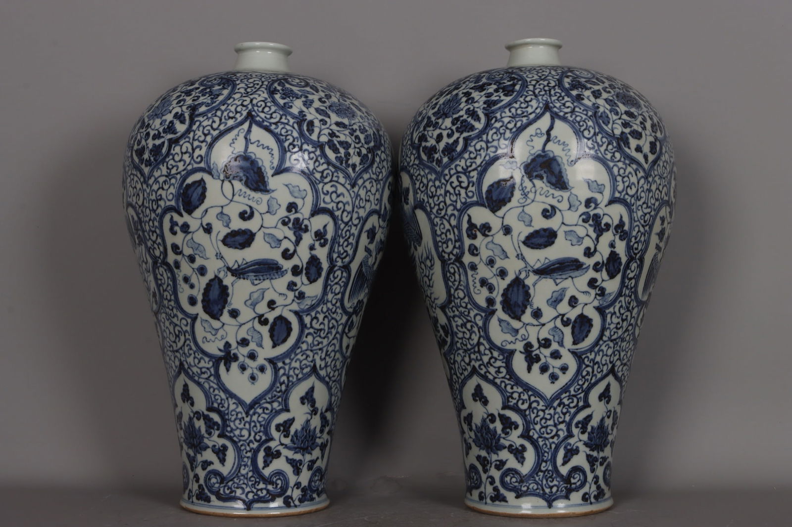 A pair of Yuan Dynasty blue and white porcelain plum vases with openwork windows depicting flowers,: pair of Yuan Dynasty blue and white porcelain plum vases with openwork depicting flowers, fruits, and phoenixes representing the four seasons. Each vase is 43.5 cm high, 5.5 cm in diameter at the mout