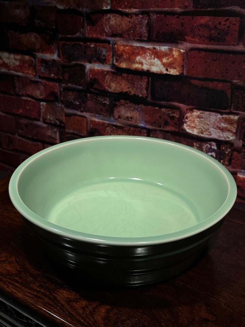 Celadon Longquan Kiln Porcelain Large Brush Washer with Folded Ridges and Floral Design: A large celadon brush washer from the Longquan kiln, decorated with floral patterns and plum-green glaze. It features a double-ringed base, a fine body, and a rich, lustrous glaze. The piece is well-f