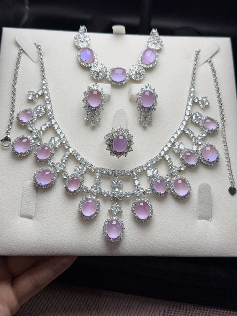 A luxurious jadeite set featuring 925 ivory jasper with diamond accents.: The jadeite, a 925 ivory variety with icy texture and diamonds, is a luxurious "set" featuring a translucent, lustrous, and exquisitely three dimensional gemstone with a rounded and full shape, perfec