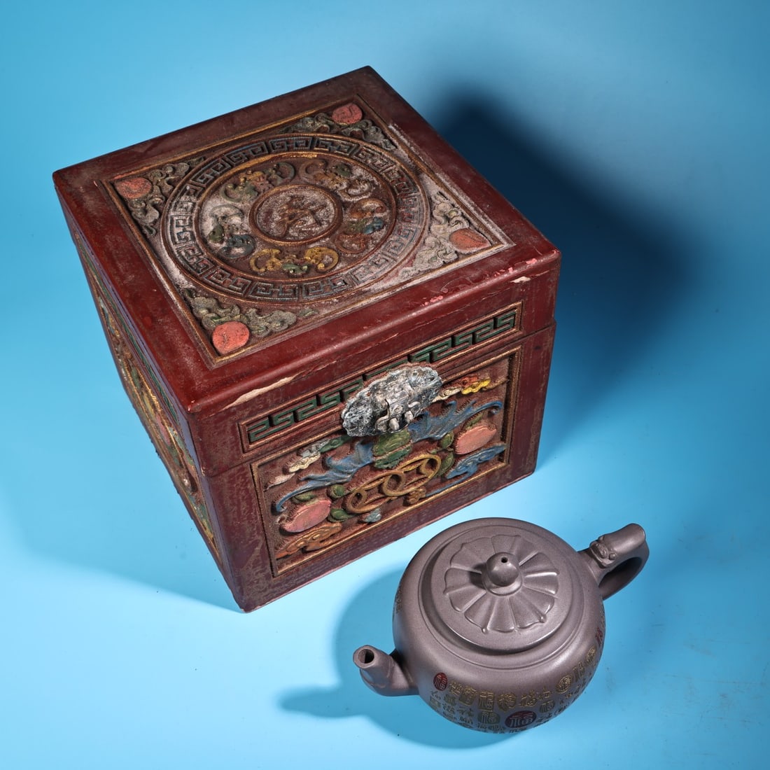 An antique, handcrafted celadon purple clay teapot: An antique, handcrafted celadon teapot, exquisitely crafted and beautifully shaped, comes with an antique wooden painted box. The teapot weighs 300 grams and is 12 cm high and 16 cm wide. Provenance:P