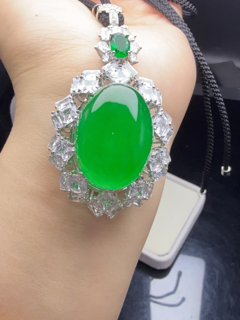 A jadeite pendant with a full green icy hue and set with an oval shape. (1 of 9)