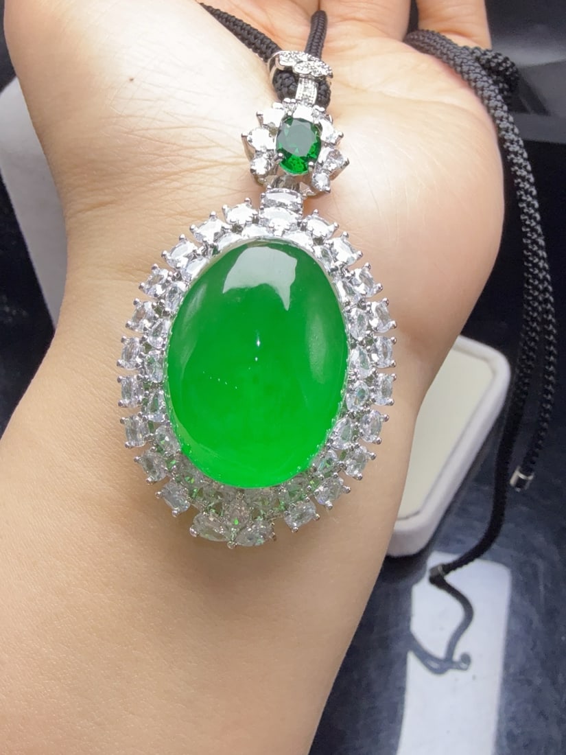 A jadeite pendant with a full green icy hue and set with an oval shape. (1 of 9)
