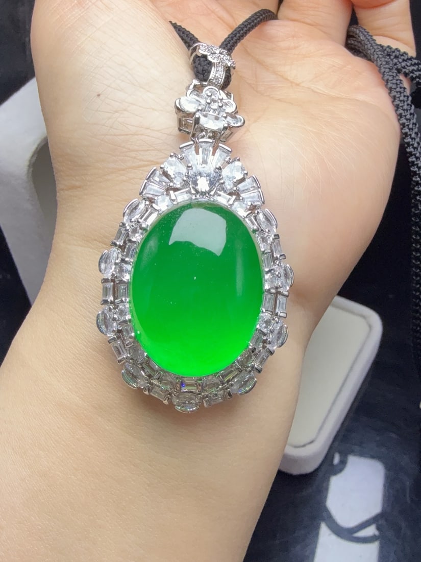 A jadeite pendant with a full green icy hue and set with an oval shape. (1 of 9)