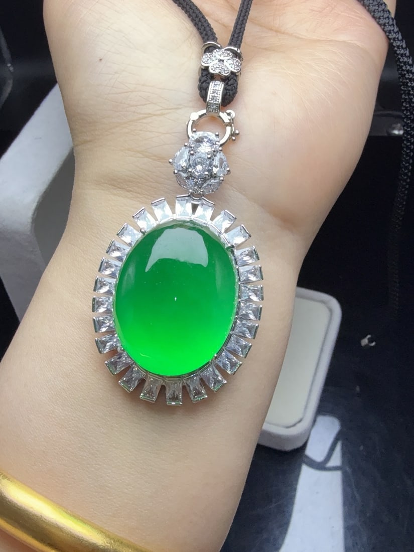 A jadeite pendant with a full green icy hue and set with an oval shape. (1 of 9)