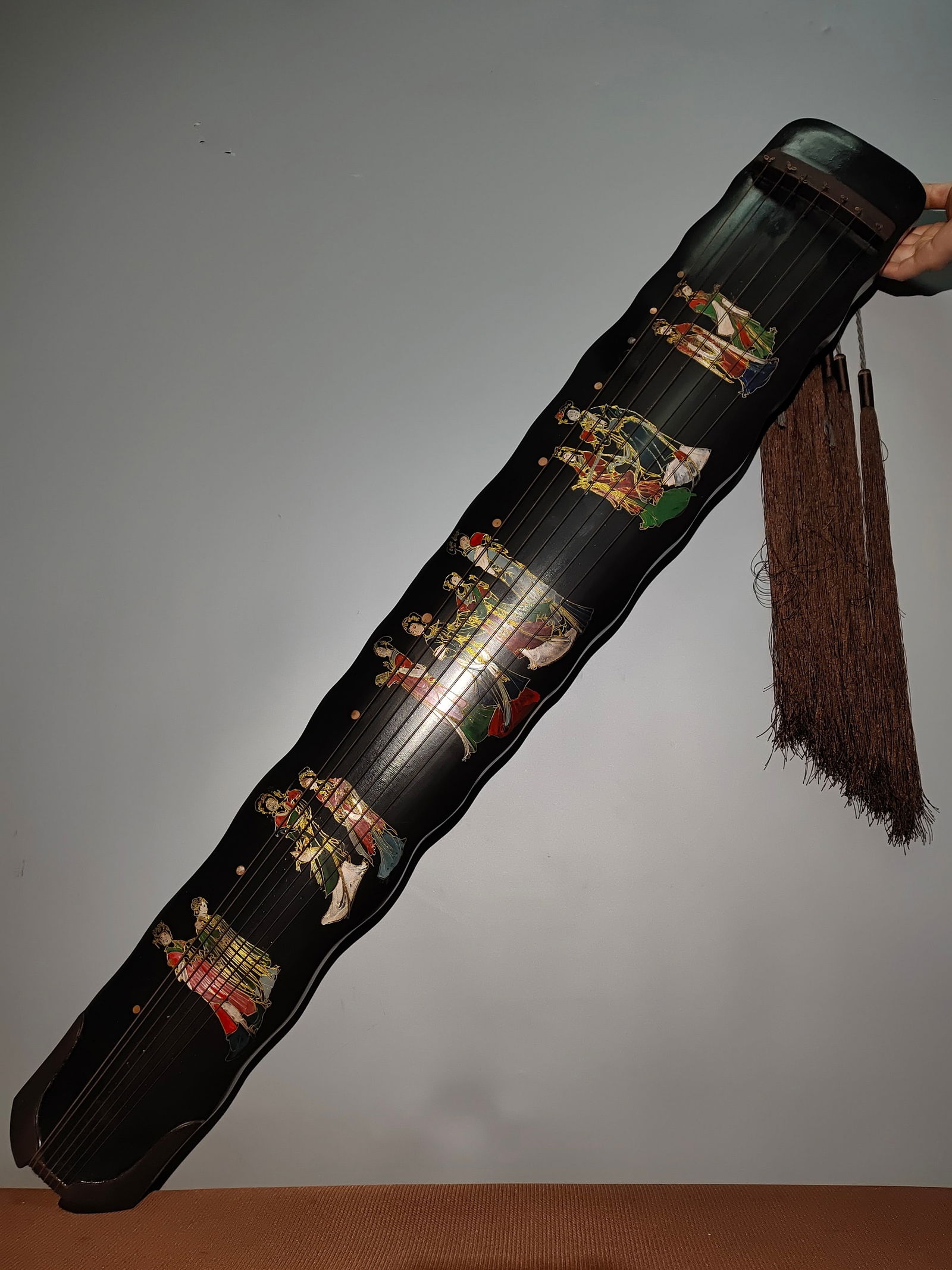 A rare antique paulownia wood lacquerware guqin (a seven-stringed zither) with lacquer inlay and: A rare antique paulownia wood lacquerware guqin (a seven-stringed zither) with lacquer inlay and painted gold decoration, featuring the "Twelve Beauties" motif. Inner inscription: Made by Zhu Zhiyuan