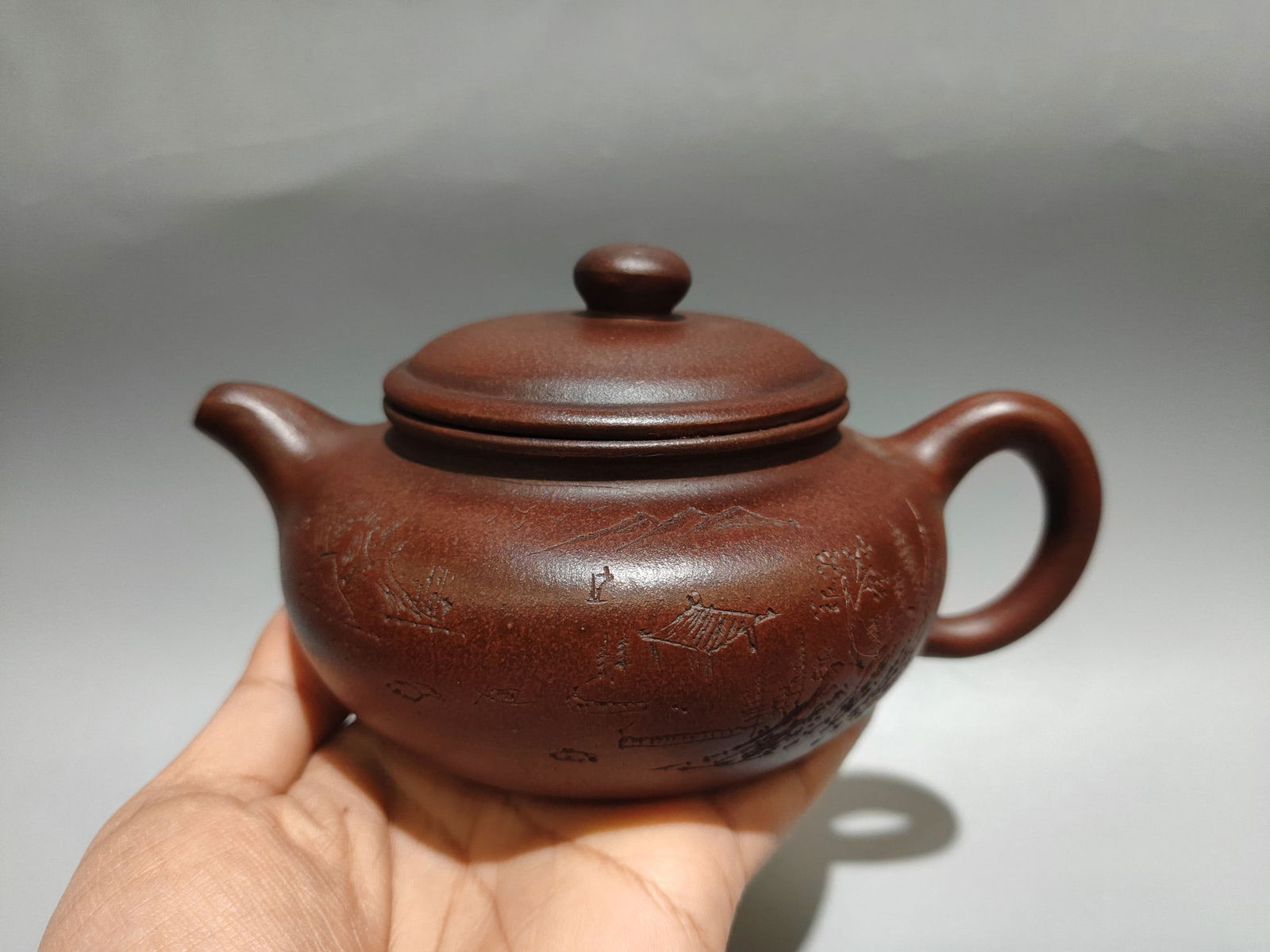 Name: Engraved Antique-Style Teapot: Name: Engraved Antique-Style Teapot; Bottom Mark: Shi Dabin; Size: 17 x 9 cm; Capacity: 360 cc; Clay: Original Red Clay Provenance:From a private collection in Sussex, United Kingdom. Our cooperative
