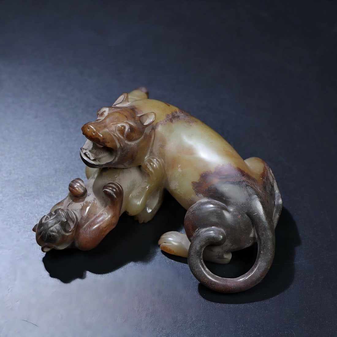 Exquisite antique piece, Hetian jade, unearthed, fully inlaid with patina, depicting a bear and: Exquisite antique, a Hetian jade carving of a bear and tiger fighting, deeply patinated and richly colored, showcasing superb craftsmanship and sharp carving. A rare and exceptional piece from a