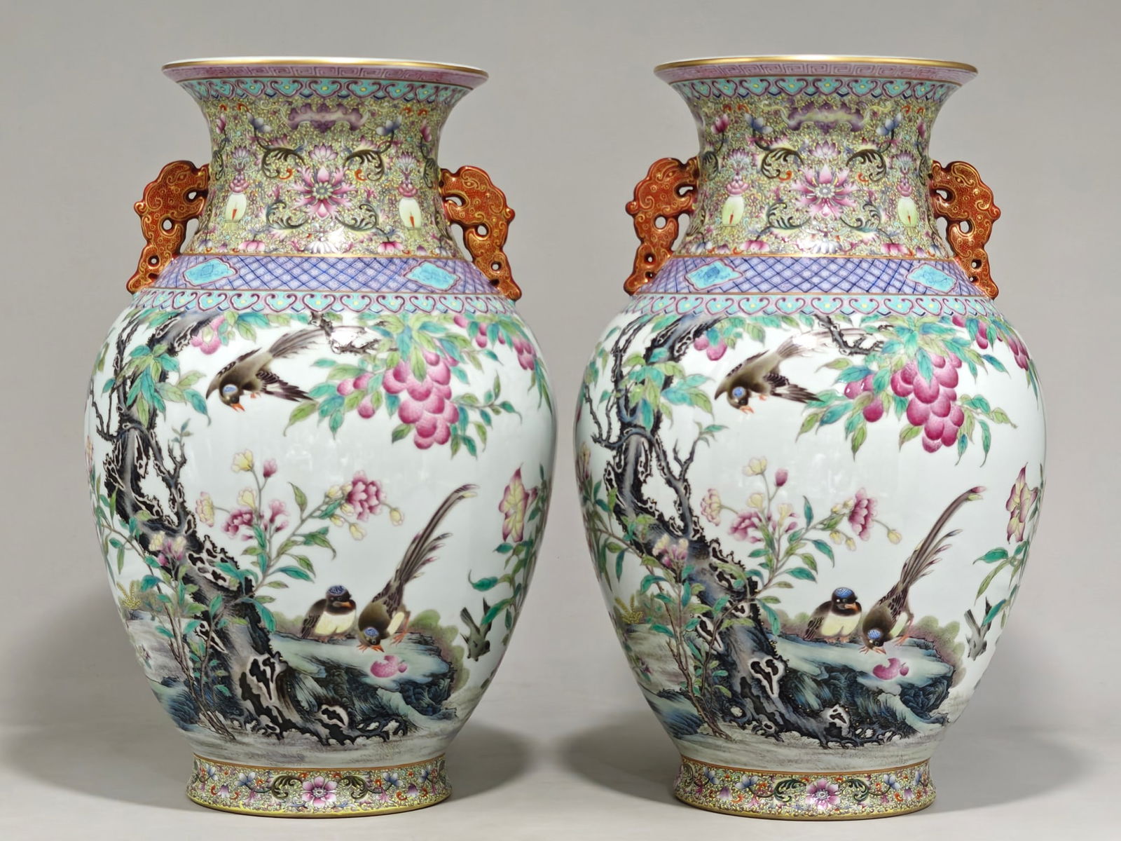 A double-eared vase with a design of lychees and ribbon birds, symbolizing good fortune, health, and: A double-eared vase with a design of lychees and ribbon birds, symbolizing good fortune, health, and longevity, bearing the mark of the Qianlong period of the Qing Dynasty. It measures 39 cm in height