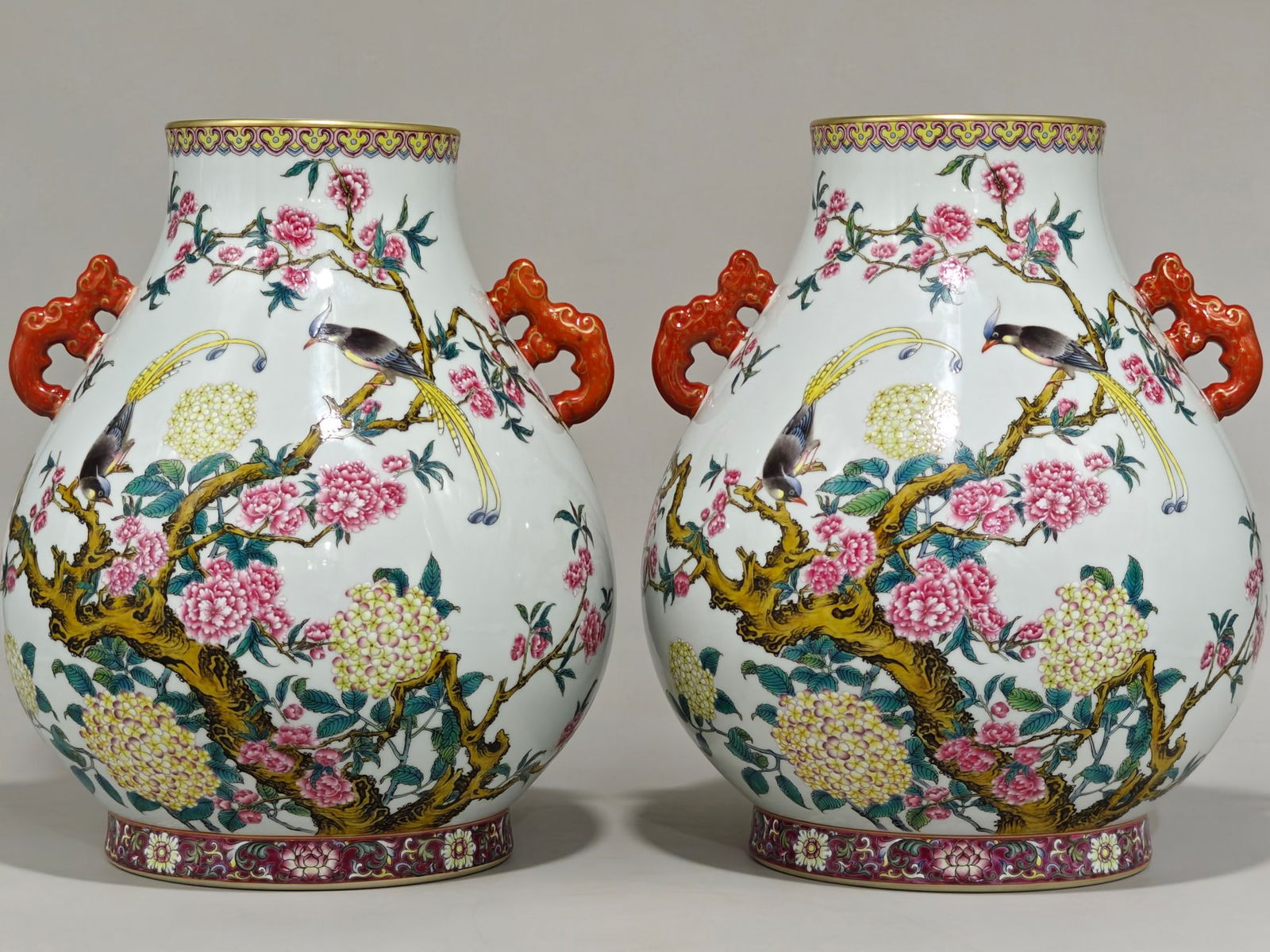 A double-eared vase with enamel decoration of peach blossoms and hydrangeas, bearing the mark of the: This is a Qing Dynasty Yongzheng period enamel vase with peach and hydrangea motifs, symbolizing reunion, happiness, and longevity. It has two handles, is 32 cm high, and has a diameter of 27 cm.