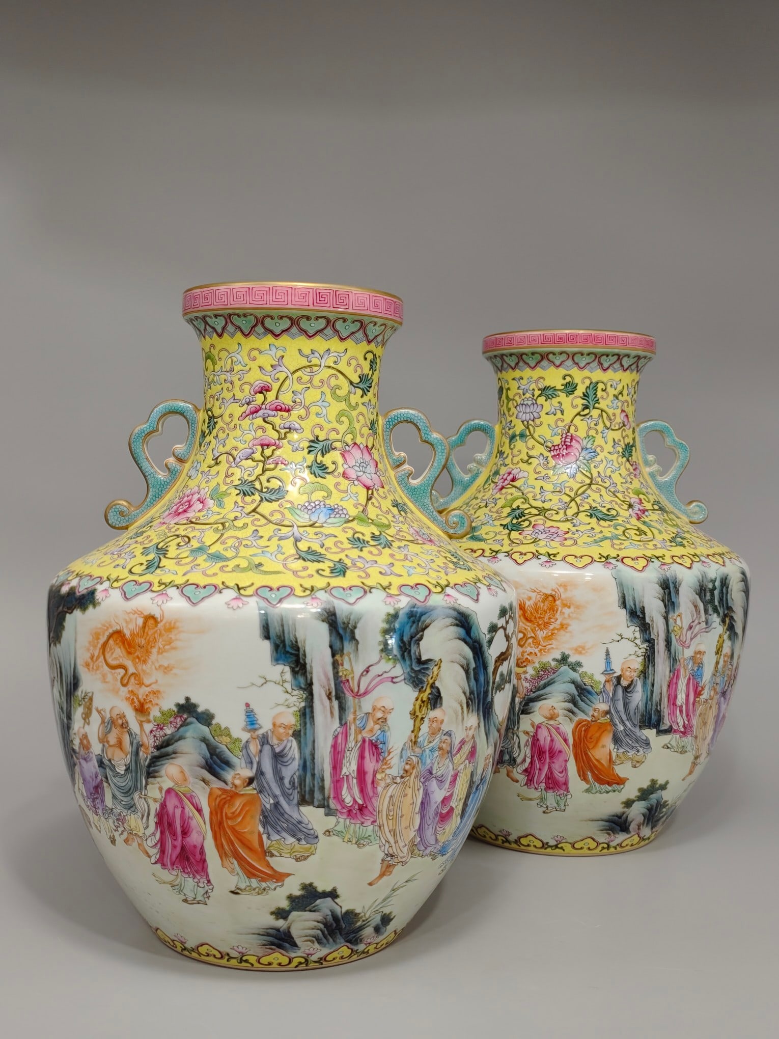 A square-shouldered vase with famille rose decoration of lotus scrolls and figures of eighteen: square-shouldered vase with two handles, 38 cm in height and 28 cm in diameter, bearing the mark of the Qianlong period of the Qing dynasty, decorated with a lotus scroll design and eighteen Arhats
