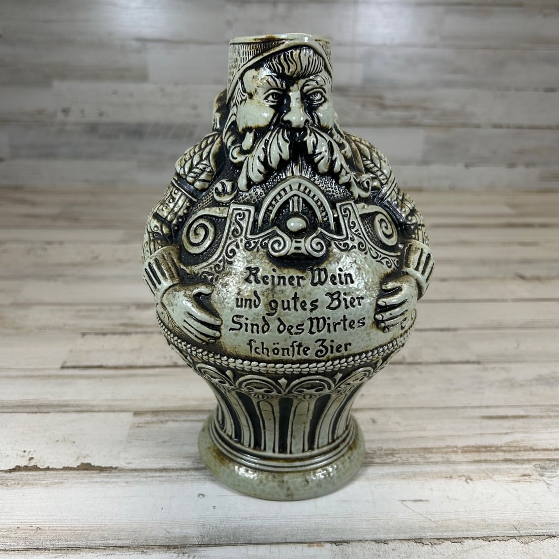 Vintage German Castlerock PEAK Germany "Reiner Wein" Beer Stein Jug: This vintage stoneware beer stein jug from Germany features an intricately molded design depicting a jovial man with a flowing beard and elaborate attire, reminiscent of medieval or Renaissance figure
