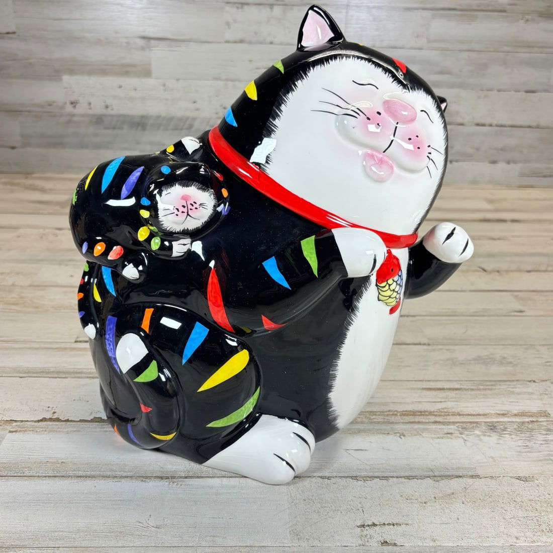 Vintage Ceramic Cat Cookie Jar Black White Colorful Mid-Century Style: This charming vintage ceramic cookie jar features a whimsical black and white cat design with vibrant, colorful accents. The cat has a darling face with closed eyes, pink rosy cheeks, and a playful ex