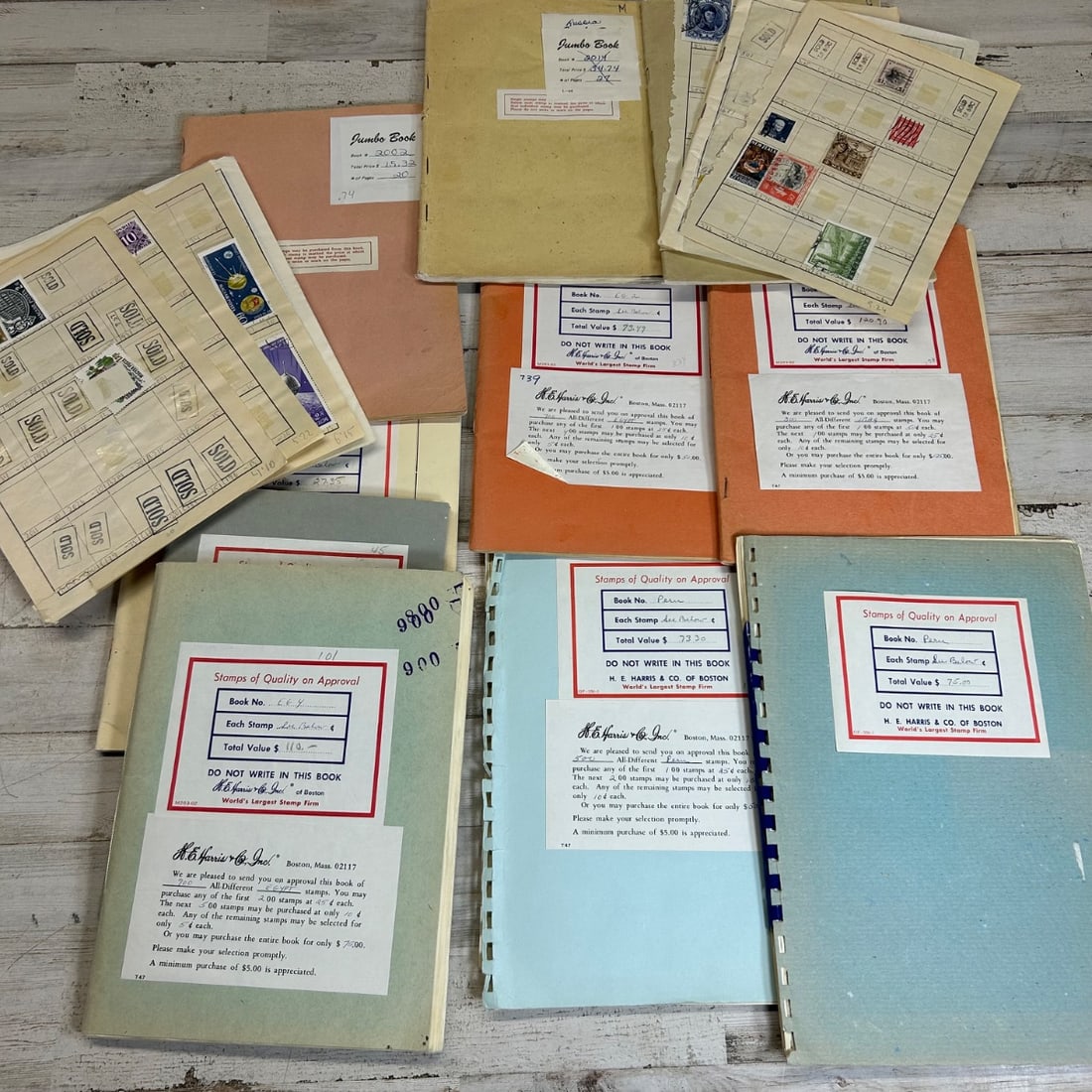 Collection of Vintage Stamps on Approval Books & Loose Stamps: This lot features a collection of vintage postage stamps, primarily presented in "Stamps of Quality on Approval" books from H.E. Harris & Co., Inc. of Boston. The books contain various stamps from dif