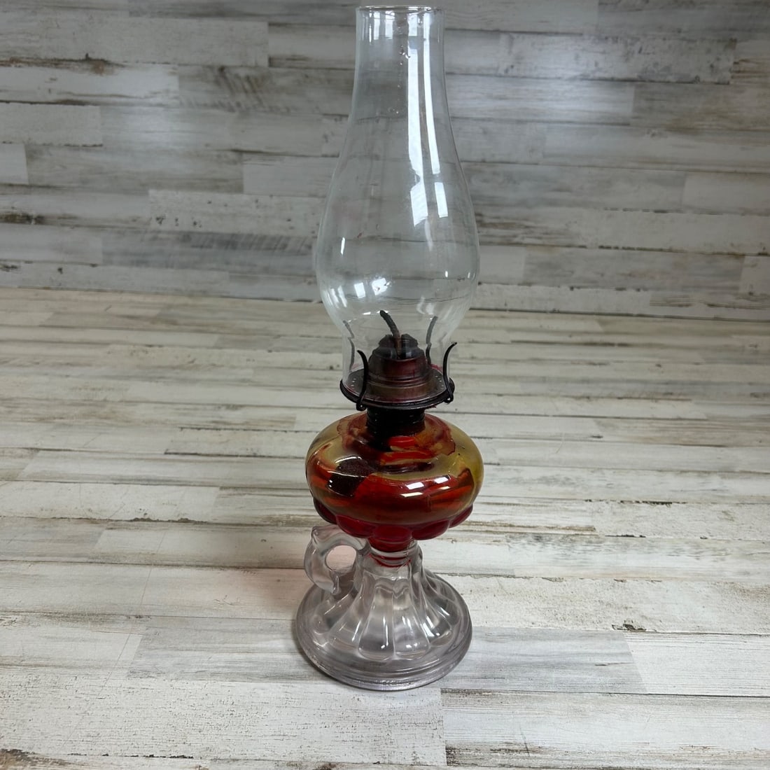 Antique Amber & Cranberry Glass Oil Lamp with Clear Handle & Hobnail Base: This antique oil lamp features a distinctive amber and cranberry glass font with swirling colors, adding a touch of vintage charm. It is supported by a clear glass base with a charming hobnail pattern