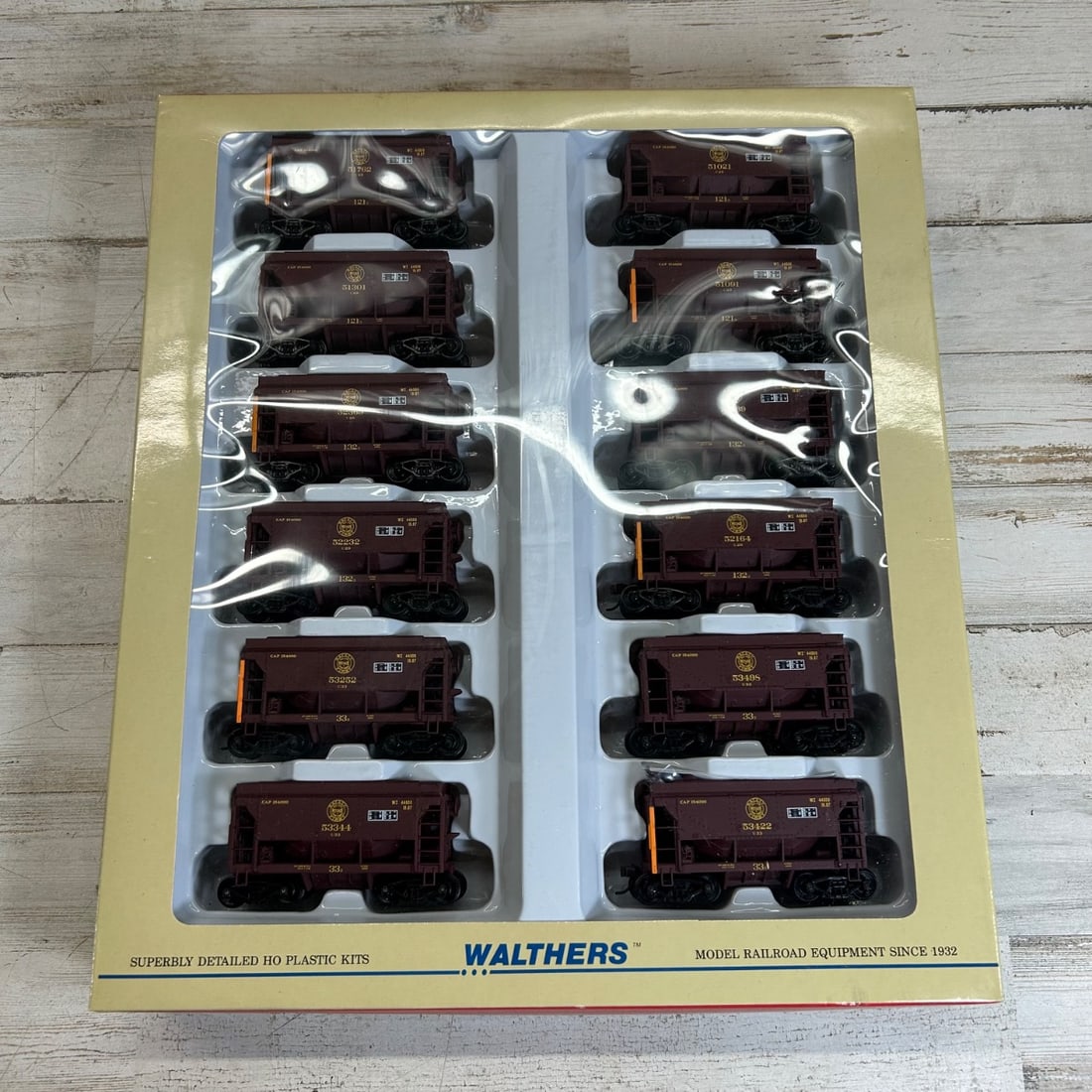Walthers HO Scale Ore Car - Taconite Version 12-Pack Duluth Missabe & Iron Ridge #2: This is a Walthers HO scale model railroad equipment set featuring 12 Taconite Ore Cars. The cars are in a dark maroon color with yellow and black detailing, specifically designed in the Duluth, Missa
