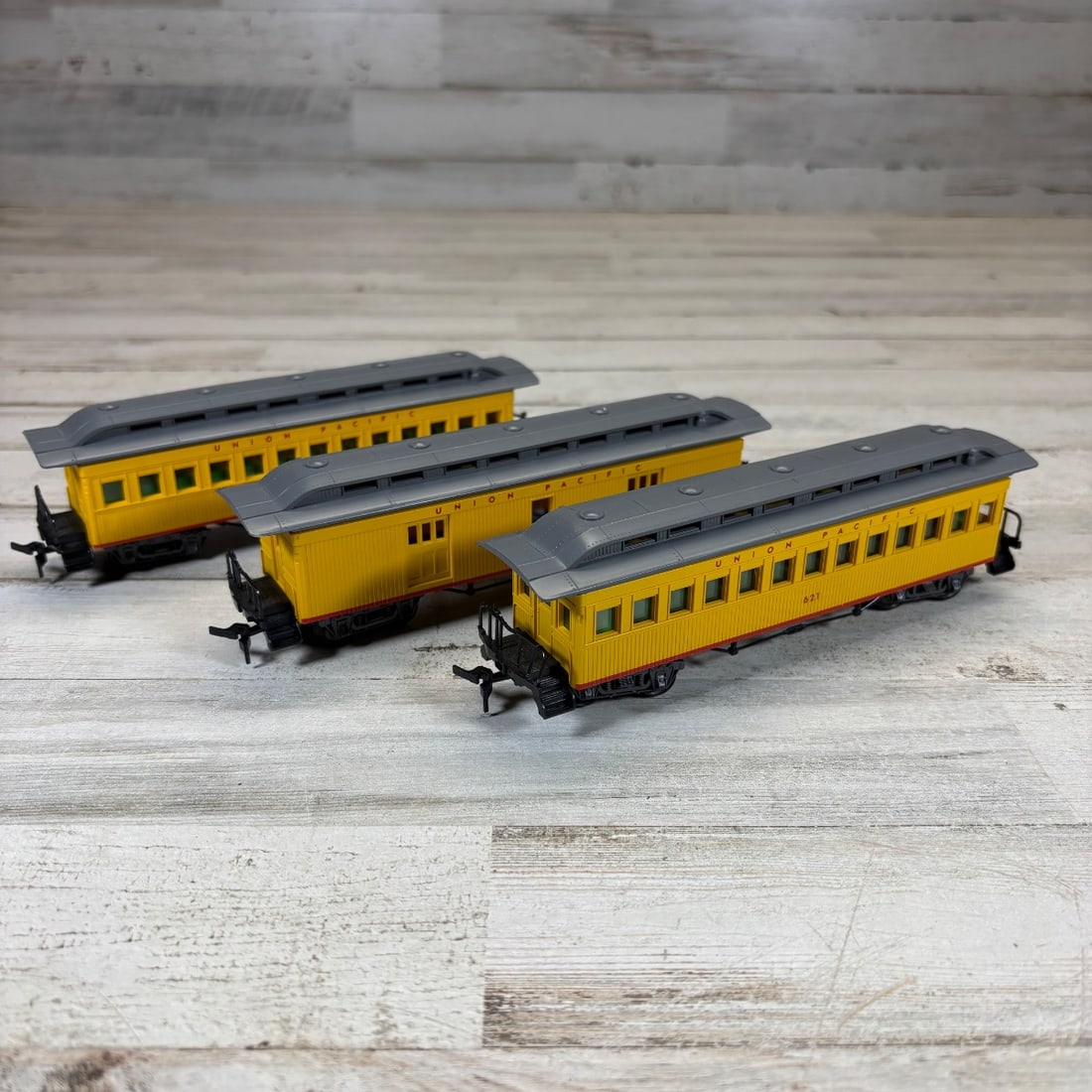 3 Vintage Union Pacific Model Railroad Passenger Cars Yellow/Gray HO Scale: This lot features three vintage model railroad passenger cars in HO scale, all branded "Union Pacific" and finished in a striking yellow with gray roofs. Each car is detailed with numerous windows and