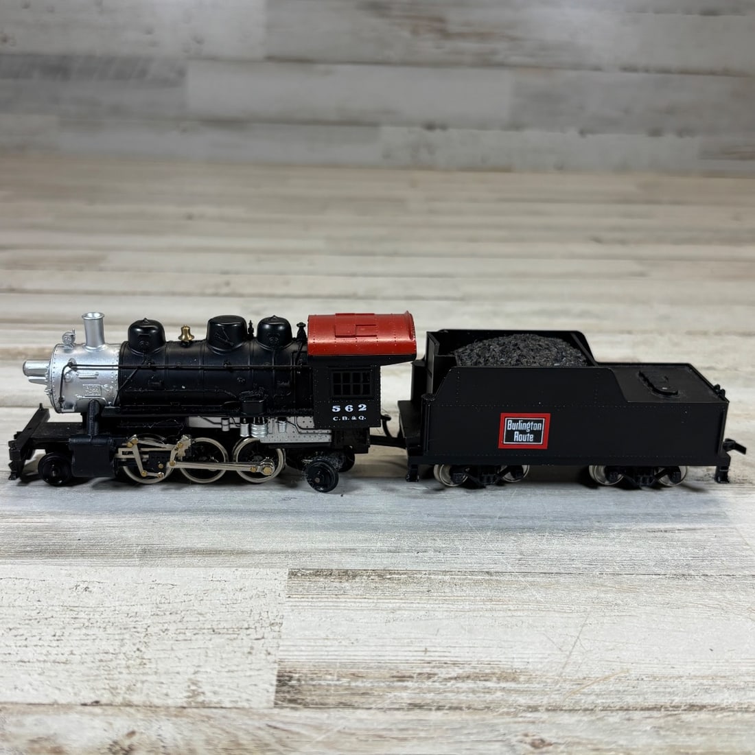 Mantua N Scale 306-062 Burlington "Prairie" 2-6-0 Steam Loco & Tender Model Train: This is a Mantua N Scale model train set featuring a Burlington "Prairie" 2-6-0 steam locomotive and tender. The locomotive is black with silver and red accents, numbered 562 C.B.&Q. The tender is als