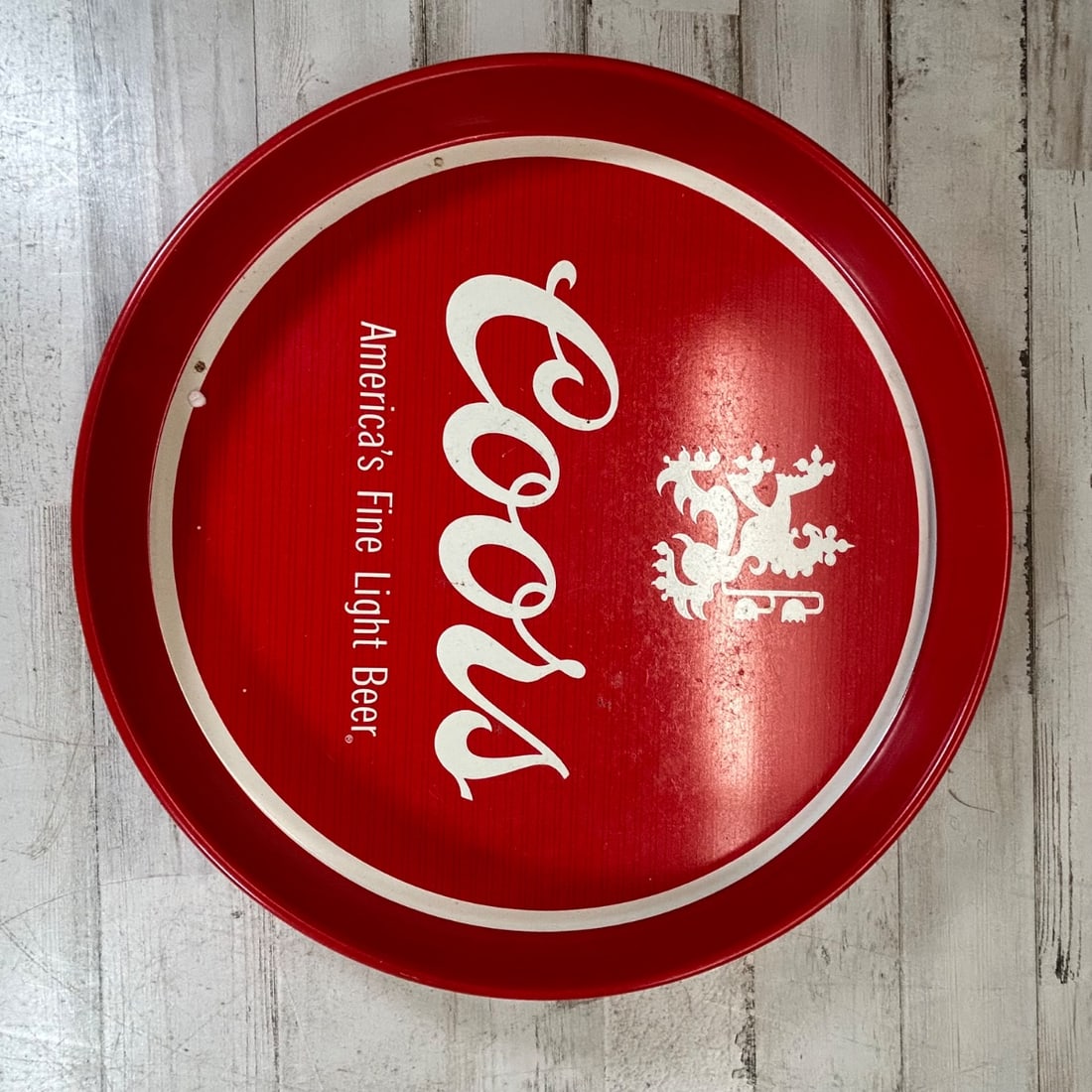 Vintage Coors America's Fine Light Beer Metal Serving Tray Red White Round: Here is a vintage Coors "America's Fine Light Beer" metal serving tray. The tray is round with a red background and white lettering and graphics, featuring the Coors logo and the Coors crest. Along th