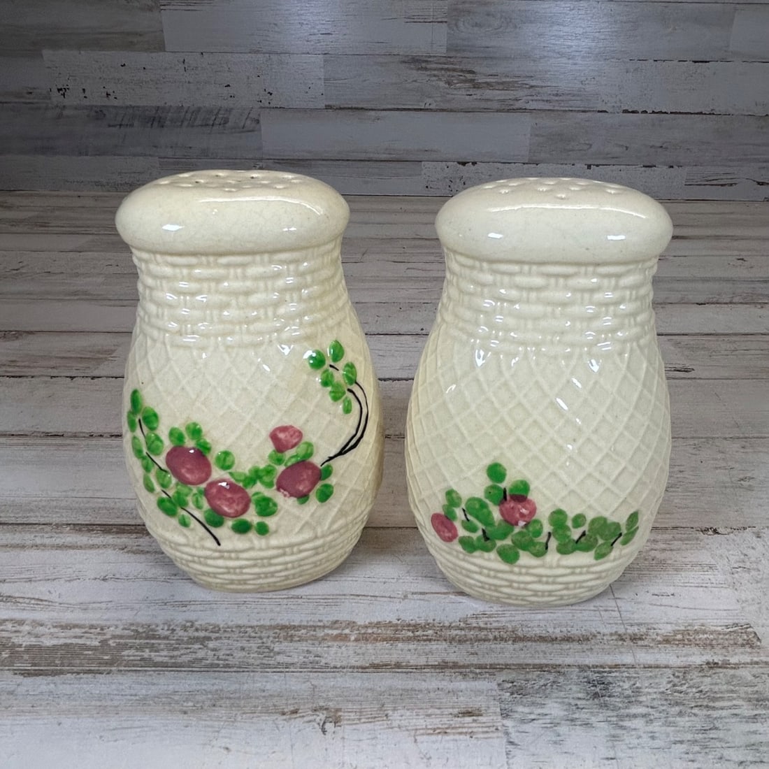 Vintage "Made in Japan" Cream Ceramic Basketweave Salt & Pepper Shakers: This charming set of vintage salt and pepper shakers features a classic cream-colored ceramic construction with an intricate basketweave texture. Each shaker is adorned with hand-painted floral motifs