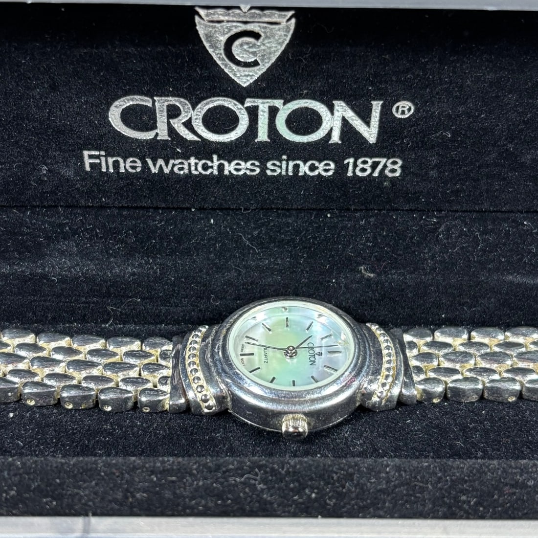 Croton Ladies Sterling Silver Mother of Pearl Dial Quartz Watch: This elegant ladies Croton watch features a shimmering mother-of-pearl dial with silver-tone hands and indices. The watch is housed in a sterling silver case with a decorative bezel and is fitted with
