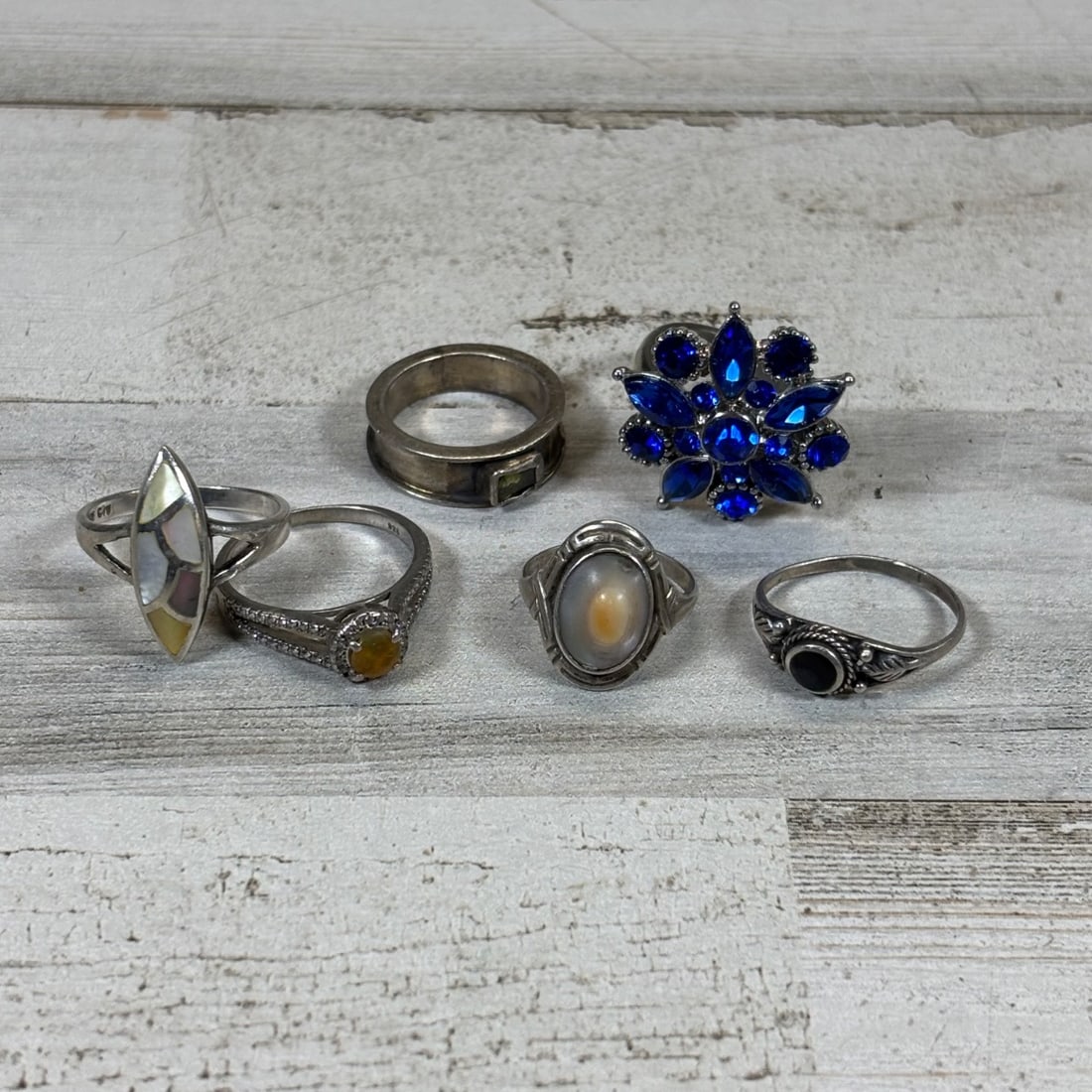 Lot of 6 Vintage Rings: Sterling Silver, MOP, Blue Gemstone Cluster: This collection features six vintage rings with various designs and materials, offering a diverse selection for collectors. Included are sterling silver pieces, one with a marquise-shaped inlay of mot