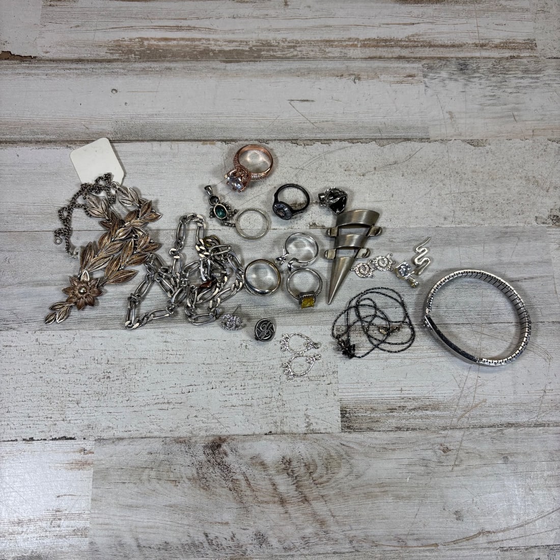 Sterling Silver Assorted Vintage & Modern Jewelry Lot: Rings, Necklace, Bracelet, Charms: This Sterling Silver lot features a diverse collection of jewelry, including rings, a detailed filigree necklace, a modernist spike pendant statement piece, a Figaro link chain, several other necklace