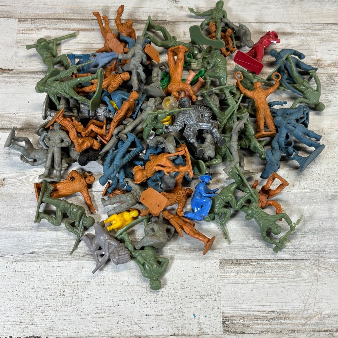 Vintage Plastic Toy Soldiers Lot Mixed Colors/Styles - Military & Knight Figures: This lot features a diverse collection of vintage plastic toy soldiers and figures in various colors including green, orange, blue, gray, and a single yellow piece. The collection includes military-st