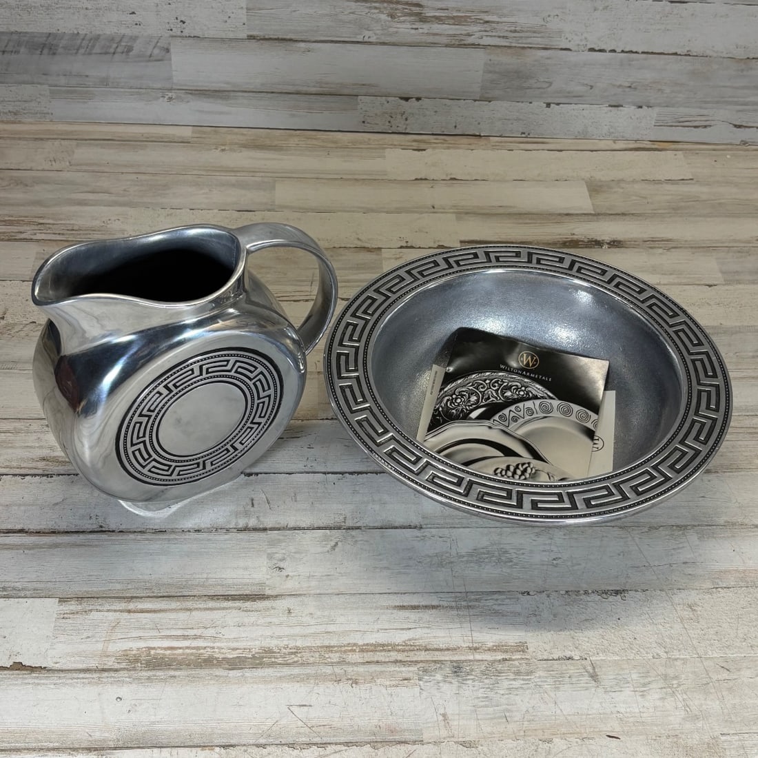 Wilton Armetale Greek Key Pitcher & Bowl Set With Brochure: This is a striking Wilton Armetale pitcher and matching bowl set, both decorated with the iconic Greek Key pattern. The pieces are crafted from Armetale, a unique metal alloy known for its durability