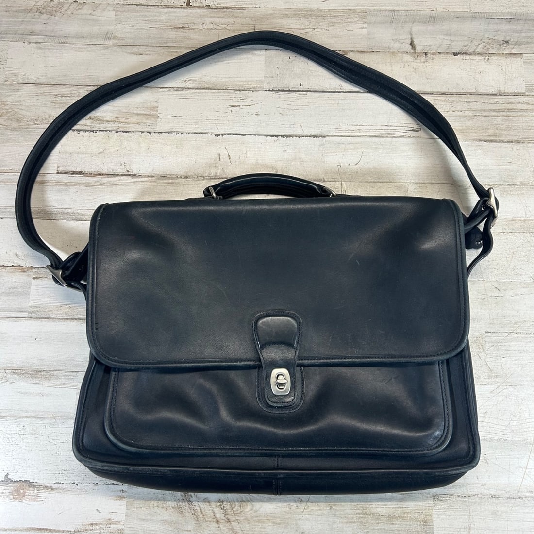 Vintage Coach "City Bag" Leather Messenger Satchel Black Leather Bag: This is a vintage Coach City Bag, a classic messenger-style satchel crafted from durable black glove-tanned cowhide leather. It features a top handle and an adjustable shoulder strap for versatile car