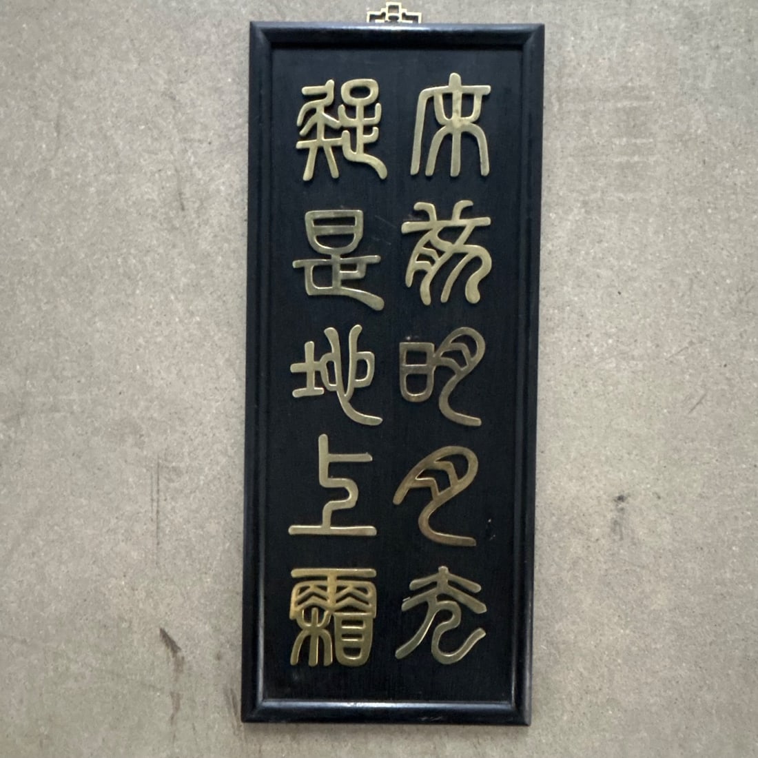 Vintage Asian Wall Art Brass Characters on Black Wood Panel Made in Hong Kong: This vintage wall art features raised brass characters mounted on a dark, possibly lacquered, wood panel. The characters appear to be Chinese or Japanese calligraphy, arranged in two vertical columns.