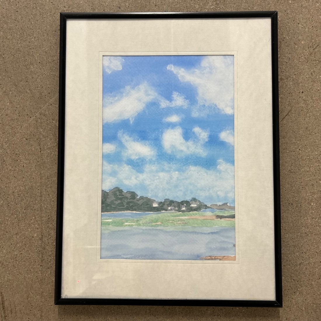 Original Watercolor Landscape Painting by "Scruggs" Dated 1998, "Happy Birthday Rob": This charming watercolor painting depicts a serene landscape with a tranquil body of water in the foreground, rolling green hills dotted with houses in the mid-ground, and a vibrant blue sky filled wi