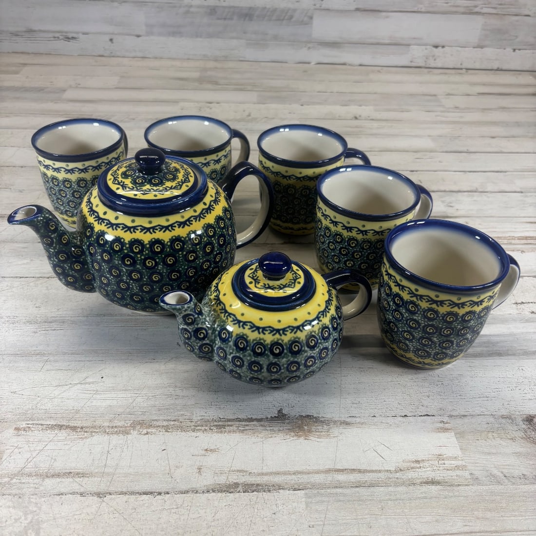 Boleslawiec Pottery Teapot & 5 Mugs Set Hand Painted Poland Blue Yellow: This charming Boleslawiec pottery set includes one teapot and five mugs, all hand-painted in vibrant blue and yellow hues with intricate detailing. The pattern features traditional Polish motifs, show