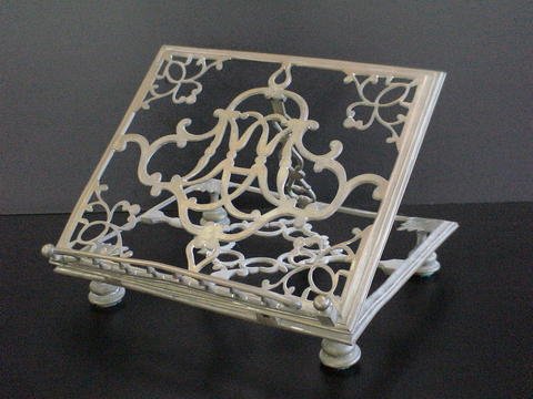 Heavy brass book display stand, marked with an M: Heavy brass book display stand, marked with an M on base of left side and an R on the base of the right side, measures 12" by 10" by 2" high