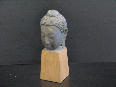 Bronze Cambodian head on a wooden base: Bronze Cambodian head on a wooden base, measures 9" tall