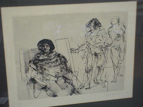 Man sitting on a chair with two people standing