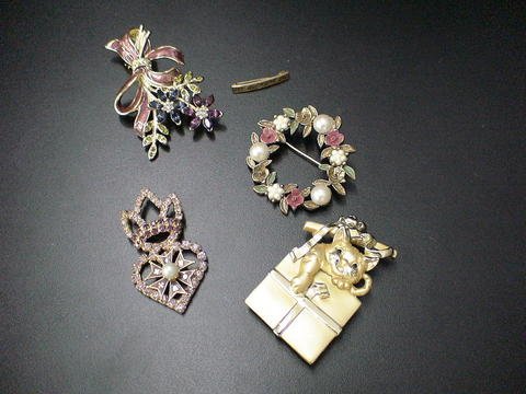 Lot of 5 costume jewelry pins: one kitty playing : Lot of 5 costume jewelry pins: one kitty playing with a present and ribbon, a floral Monet pin, another floral pin, a small narrow bar pin, and a royal pin with a crown on top.