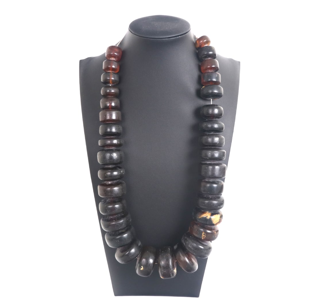 Large Chunky Amber Disc Necklace: Handsome group of amber polished disc shaped beads ranging small to large giving a cascading effect. Each bead uniquely translucent and caramel colored, with natural crystal like inclusions to some.