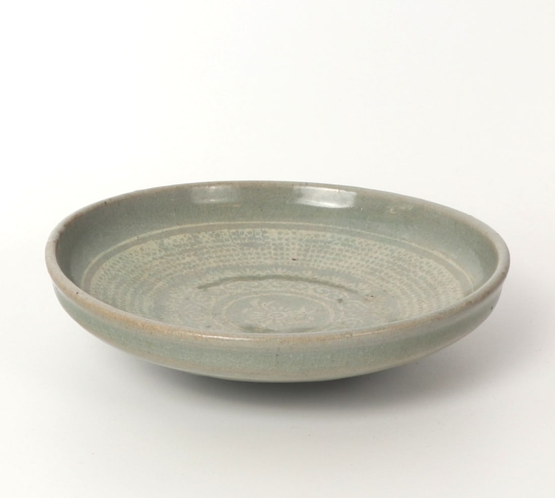 Beautiful Early Korean Porcelain Celedon Bowl: Lovely Korean celadon crackle glazed bowl with central floral stamp, and repeating foliage and dotted designs throughout. Slightly raised rim and raised unglazed foot. Decorated to the base with arche