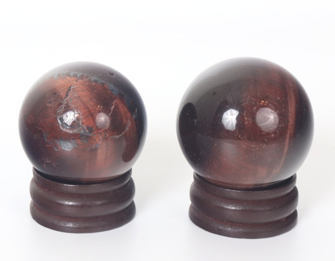 Beautiful Pair of Red Tiger's Eye Spheres on Stands: Lovely pair of red colored tiger's eye spheres, larger sphere has a wonderful natural crystal iris to the center when displayed properly. Each piece glistens with gold bands that follow the viewer as