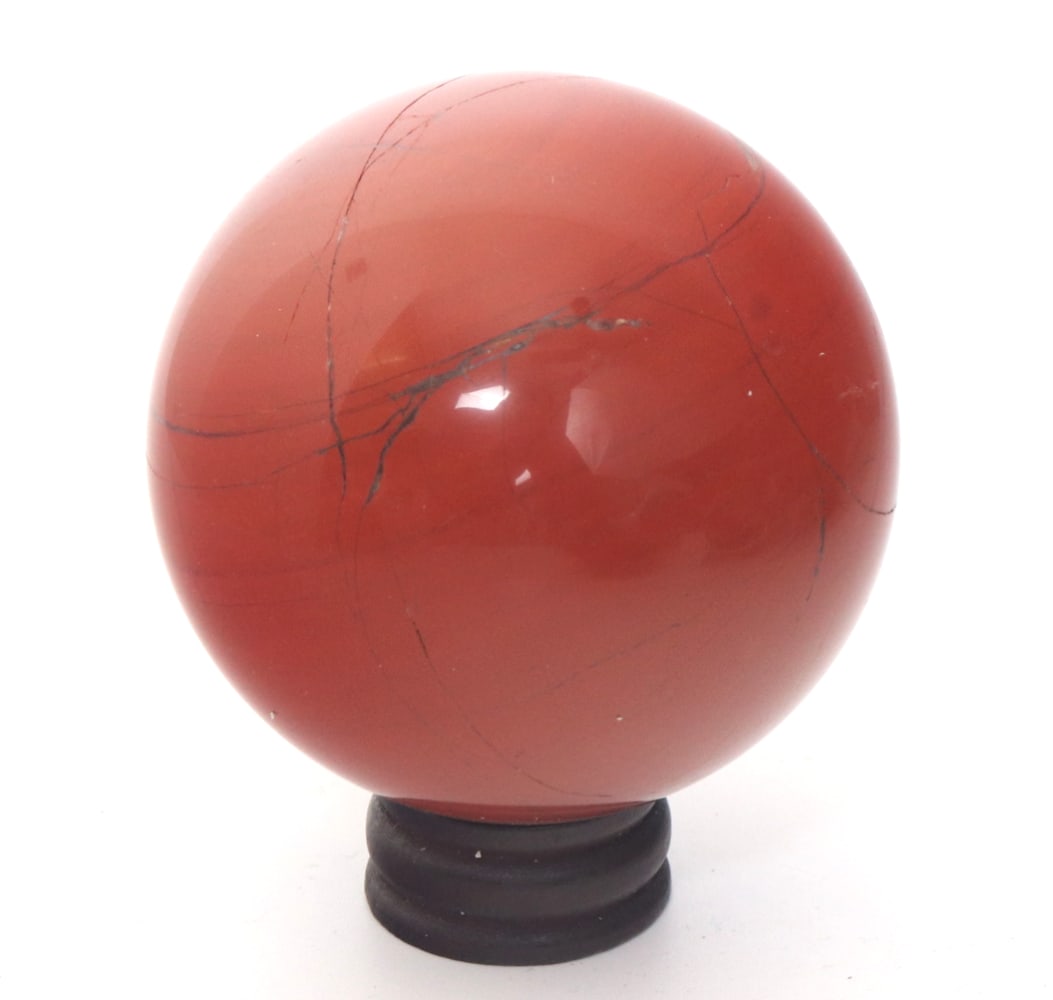 Orange Jasper Sphere on Wood Stand: Handsome burnt orange natural polished jasper sphere with inclusions throughout. Warm orange coloring with dark black and dark brown inclusions. Displayed on a custom wood base. Size: 2 3/4" H on