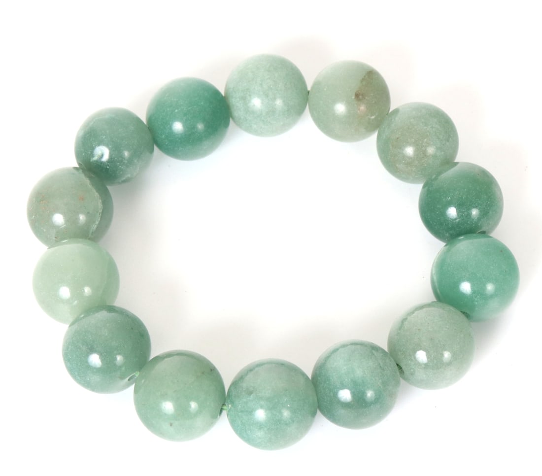 Chunky Chinese Green Jade Style Beaded Bracelet: Fourteen lovely light green jade or jade style beaded bracelet. Light green to slightly darker colors throughout with natural inclusions. Size elastic band measures 3" W inner diameter when at rest