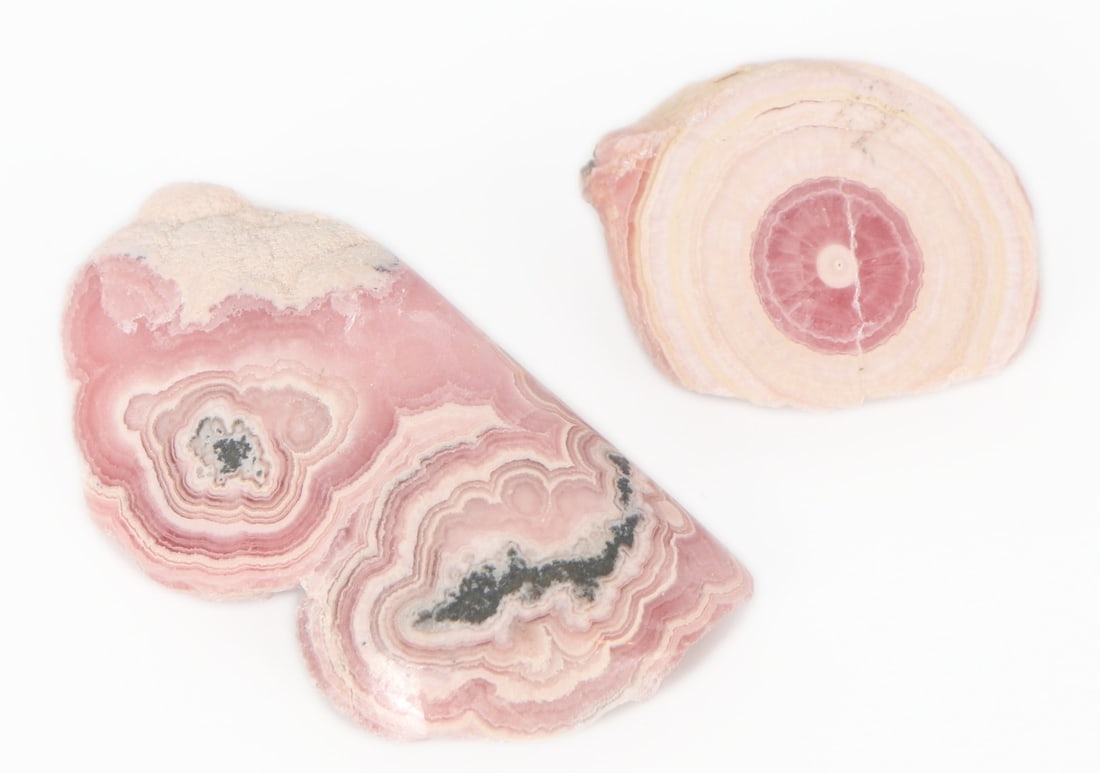 Two Pieces of Polished Rhodochrosite Mineral Specimens: Bright pink and white polished Rhodochrosite mineral specimens with beautiful crystalizations on the back of the larger piece. Both pieces exibit classic wood like rings in pink highlighted by white r