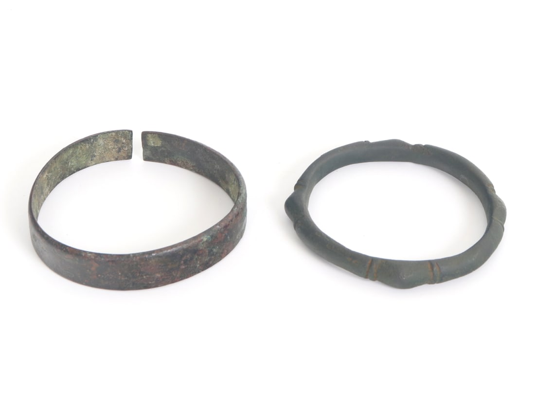 Two Bracelets - Peasant Wear Bronze Cuff & Celtic Geometric Bracelet: Wonderful pair of ancient bracelets both comprised of bronze. Left most cuff bracelet with aged patina and wear throughout. Right bracelet is in a wonderfully unique form with raised points in a geome