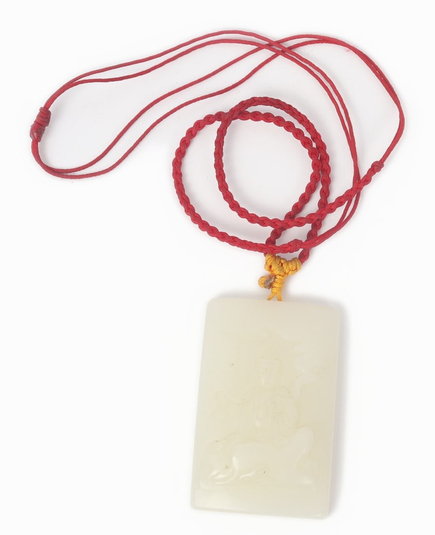 Chinese White Jade Style Pendant: Lovely Chinese white jade style pendant with Guanyin depicted to the face. She is seated with vase in one hand and appears to be casting smoke from the other. Strung on a bright red thread as shown.