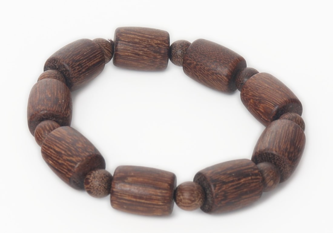 Chinese Agar Wood Beaded Bracelet: Beautiful tiger stripe Chinese agar wood beaded bracelet. Uniquely shaped tube beads and interspersed circular accent beads. Dark brown against light brown makes the piece really stand out. Size of