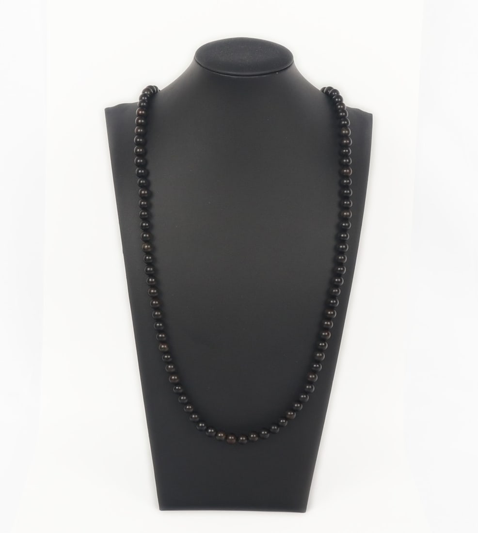 Dark Brown Agar Wood Style Rosary Necklace: Dark brown agar wood style beaded rosary in a dark brown color. Dozens of beads polished smooth with natural earthen tones throughout. Size 32" L (81.3cm L)