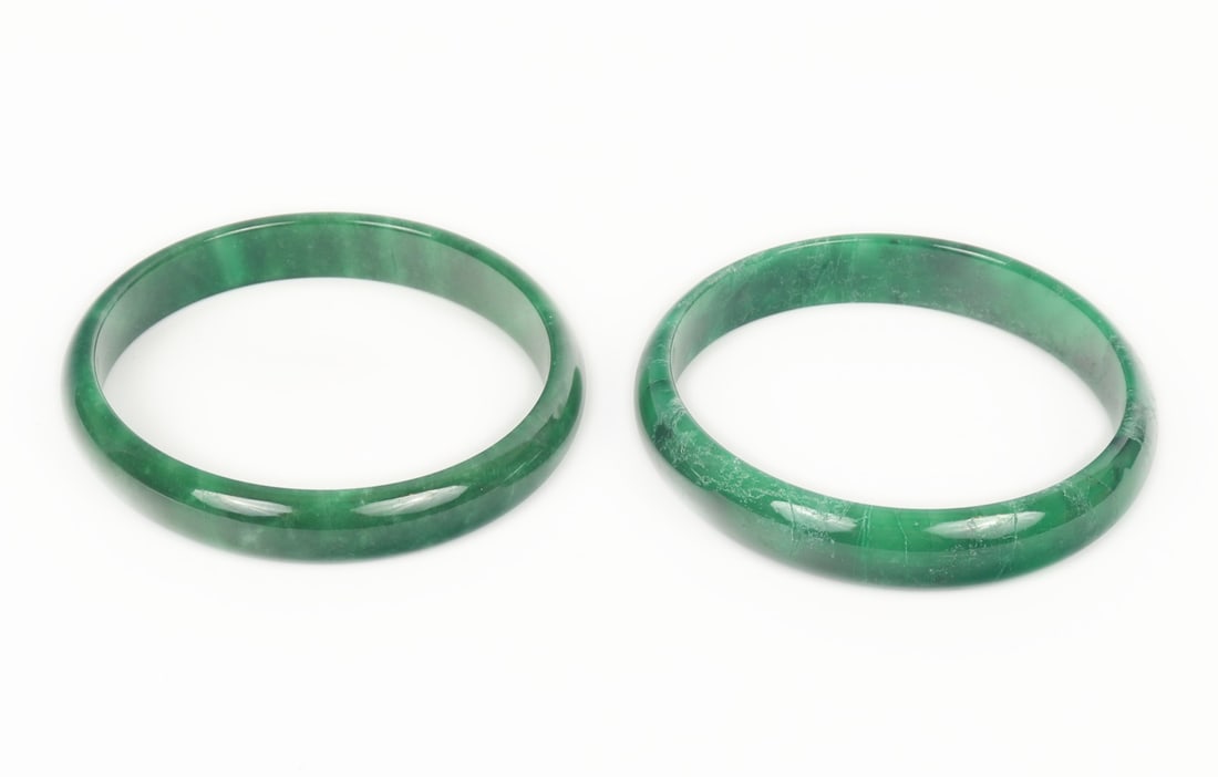 Pair of Chinese Jade Style Bangle Bracelets: Beautiful pair of dark green marbled Chinese green jade style bangle bracelets. Each with lovely translucency throughout. Size of each opening approximately 2 1/2" W (6.3cm W)
